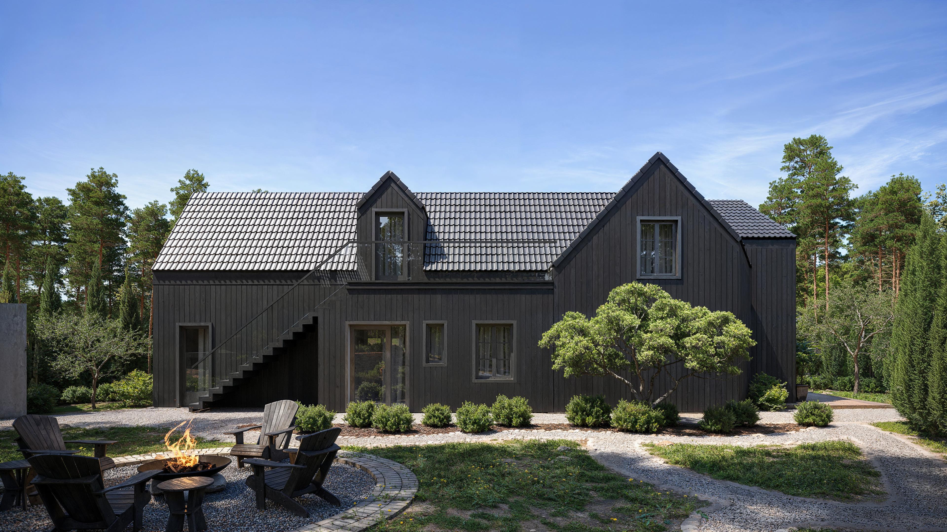 Närbild på Villa Cosmos med fokus på fasadens detaljer, stora fönster och harmonisk integration med omgivande natur.